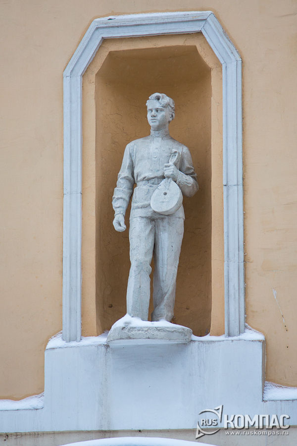 Статуя юноши с домброй на фасаде дома на Спасской 12А