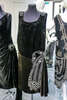 Платье-туника из черного бархата с глубоким круглым вырезом горловины и заниженной линией талии украшено бантом из бисера и страз в кастах 